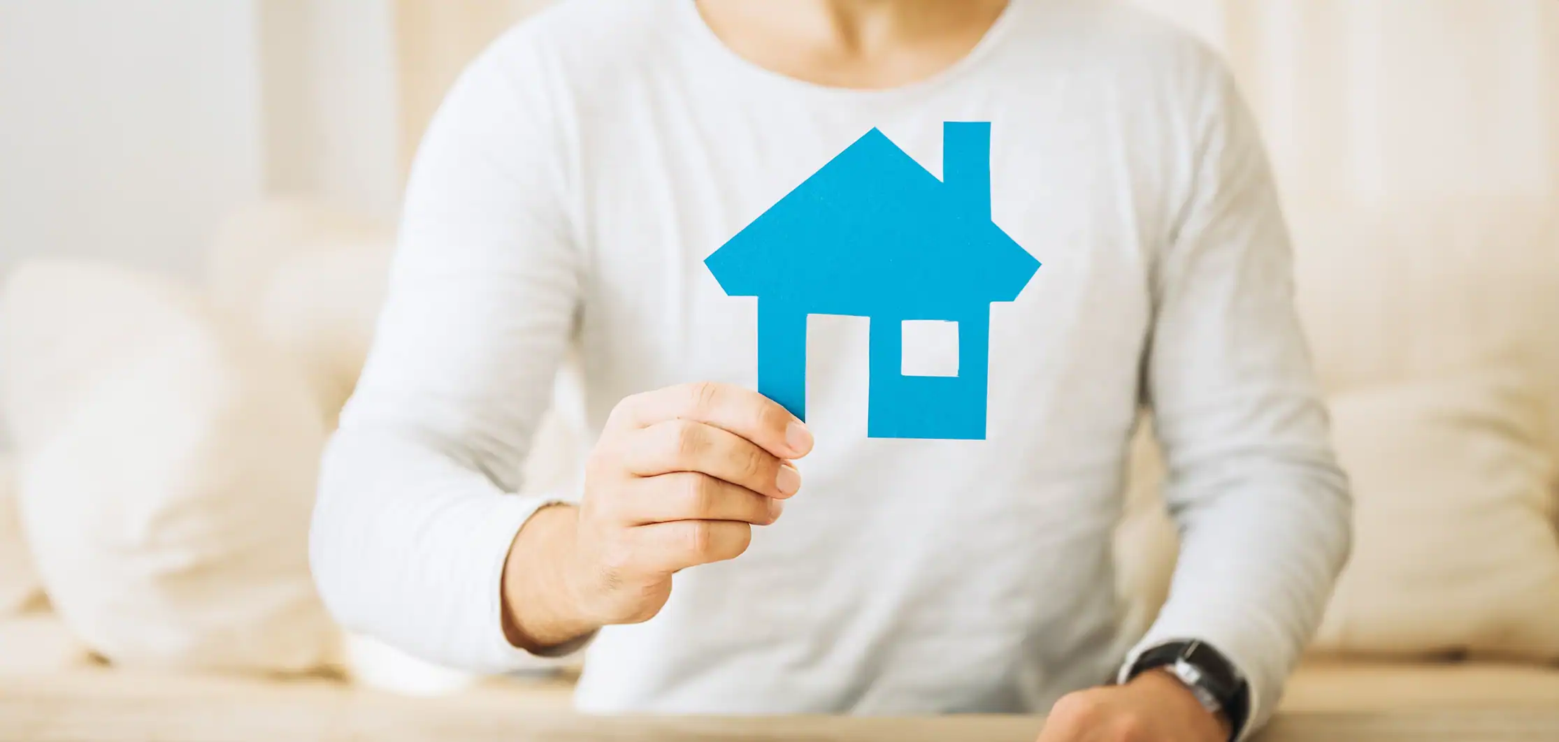 Homelessness Services person holding paper cutout of a house
