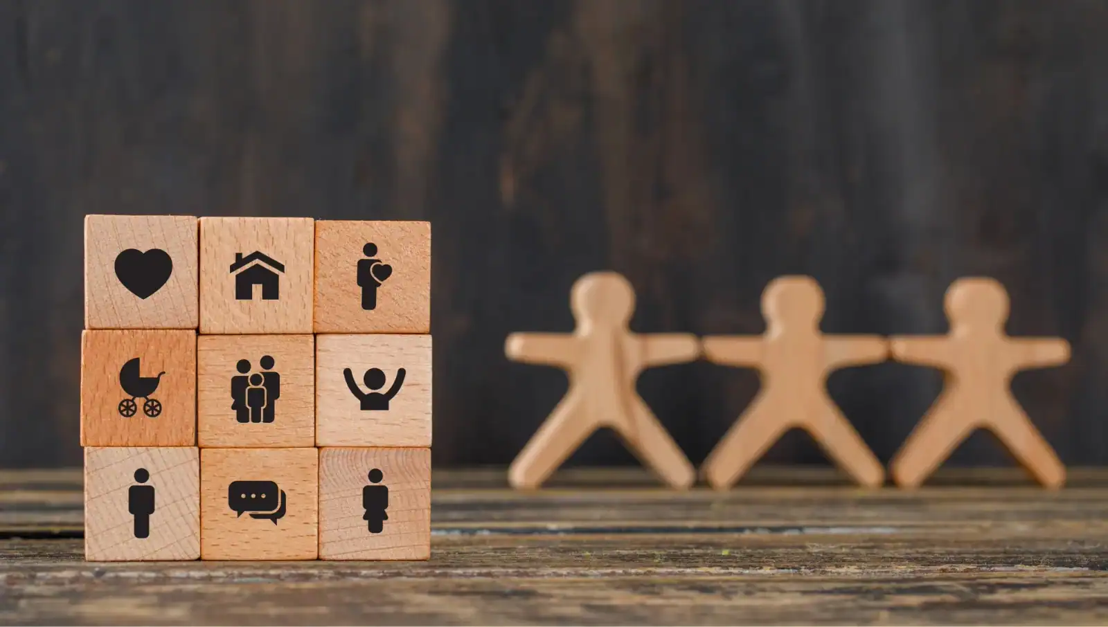 Puzzle pieces with stick figure people on them to represent teamwork.